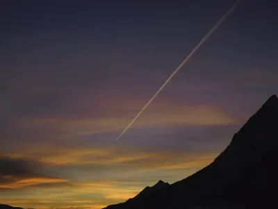 Ein Kondensstreifen durchzieht schräg den abendlichen