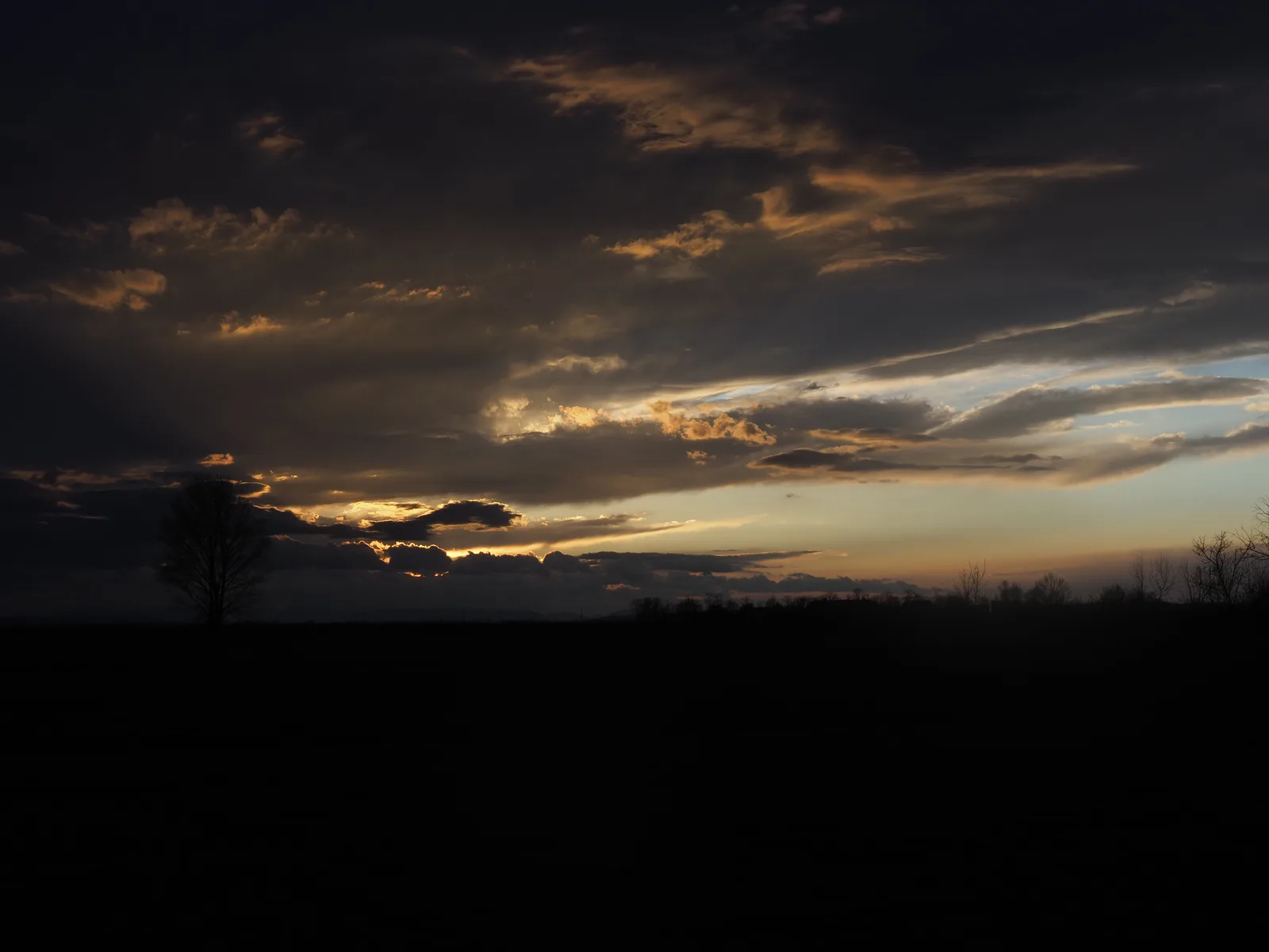 Ein schmaler Streifen goldenen Abendlichts durchbricht
